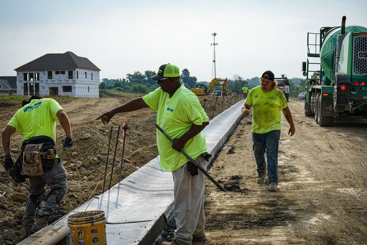 construction workers in a neighborhood installing a new curb